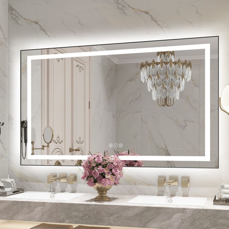 a bathroom vanity with a large mirror above it and flowers on the counter in front of it