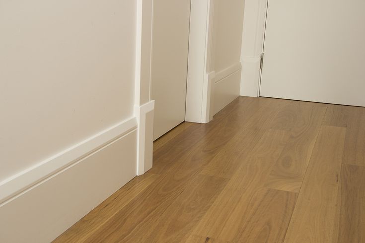 an empty room with hard wood floors and white walls