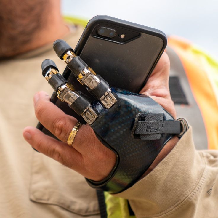 a man holding an electronic device in his hand with other devices attached to the arm