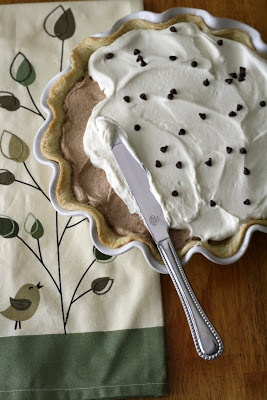 there is a pie with white frosting on it and a fork next to it