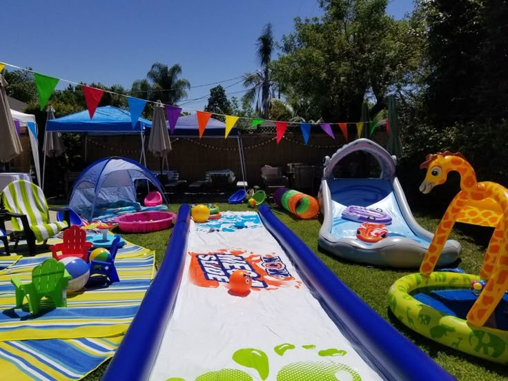 an inflatable pool is set up on the grass with toys and decorations around it