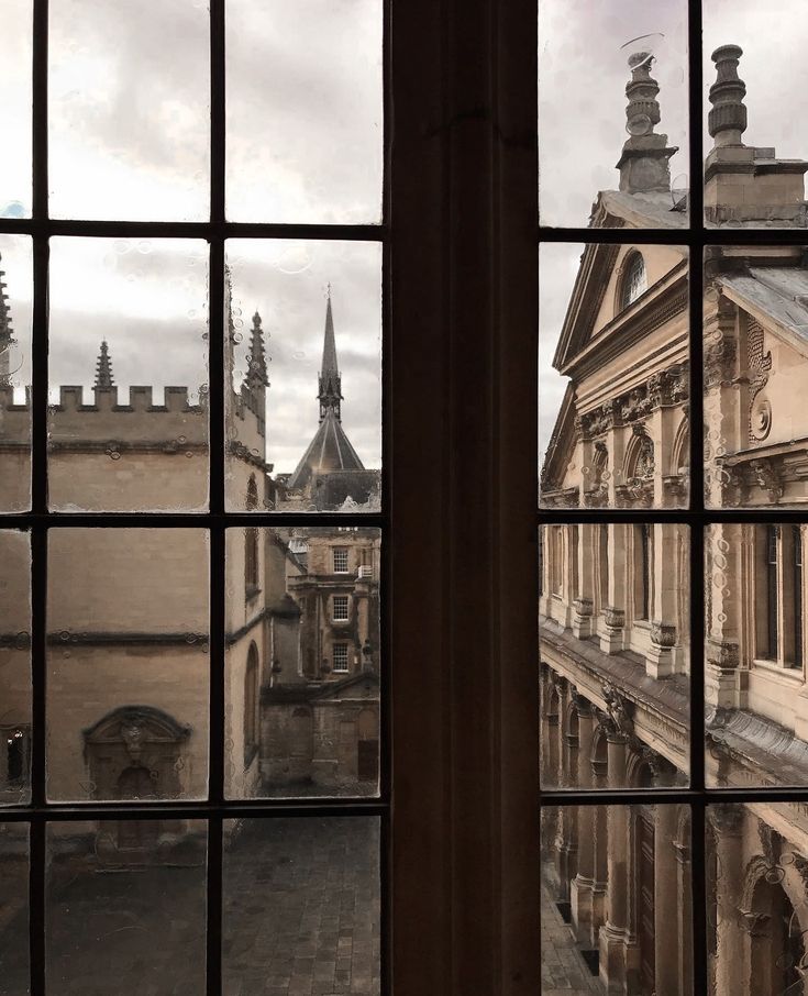 looking out the window at old buildings and spires