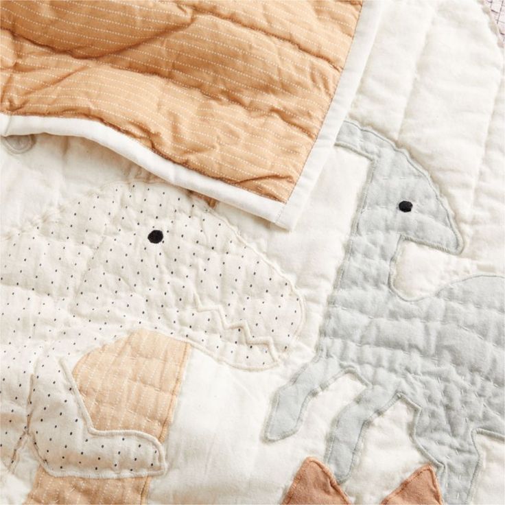 an elephant and giraffe quilted together on a bed