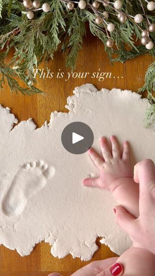 a baby's hand and foot print on paper next to a christmas wreath with the words, this is your sign