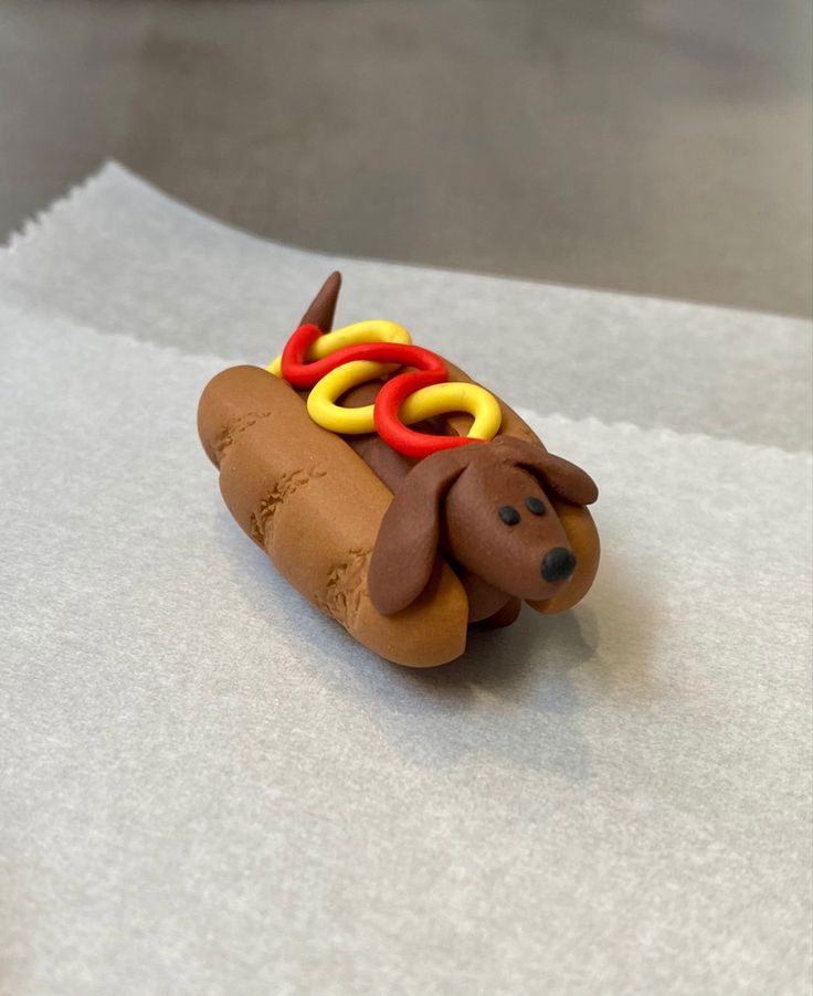 a toy hot dog with rings on it's head sitting on top of paper