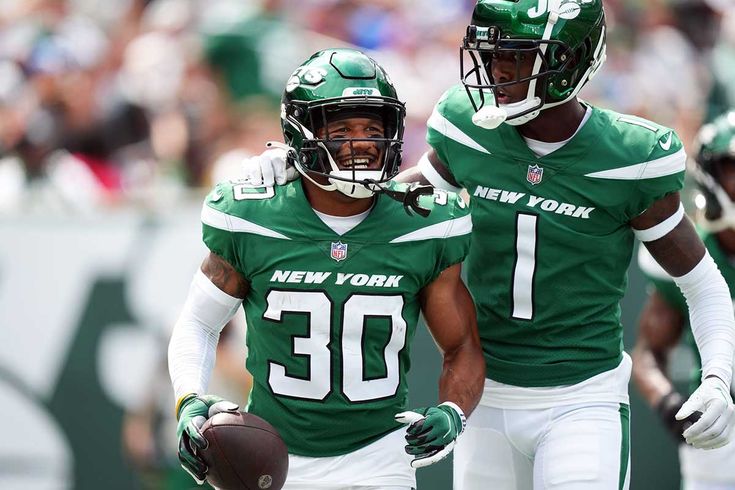 two new york jets football players walking off the field