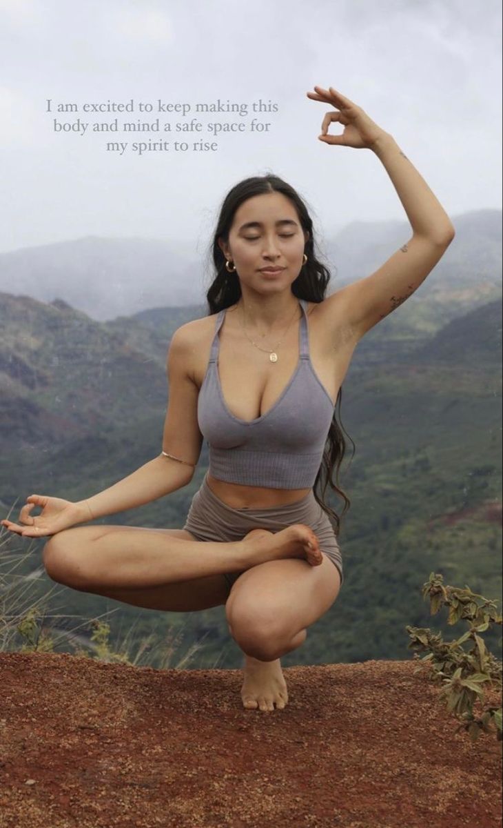 a woman is doing yoga on top of a mountain