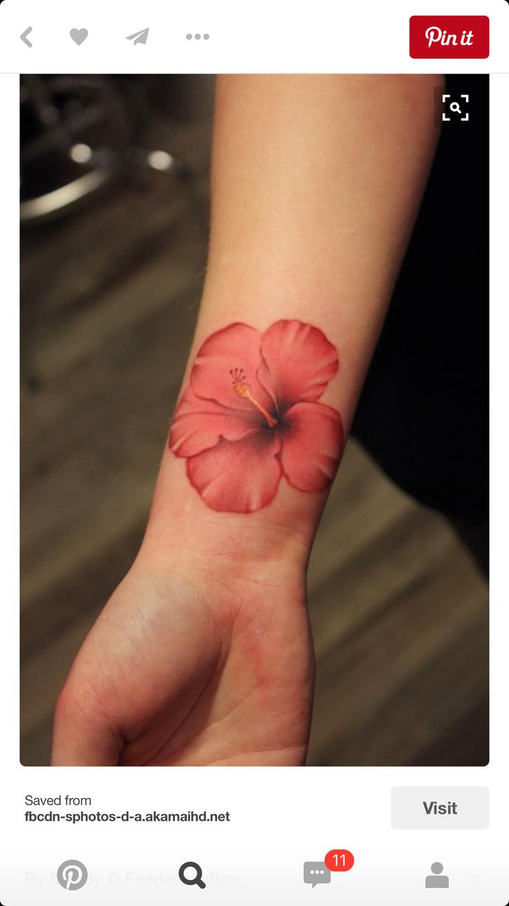 a woman's wrist with a red flower on it and the word love written in black ink