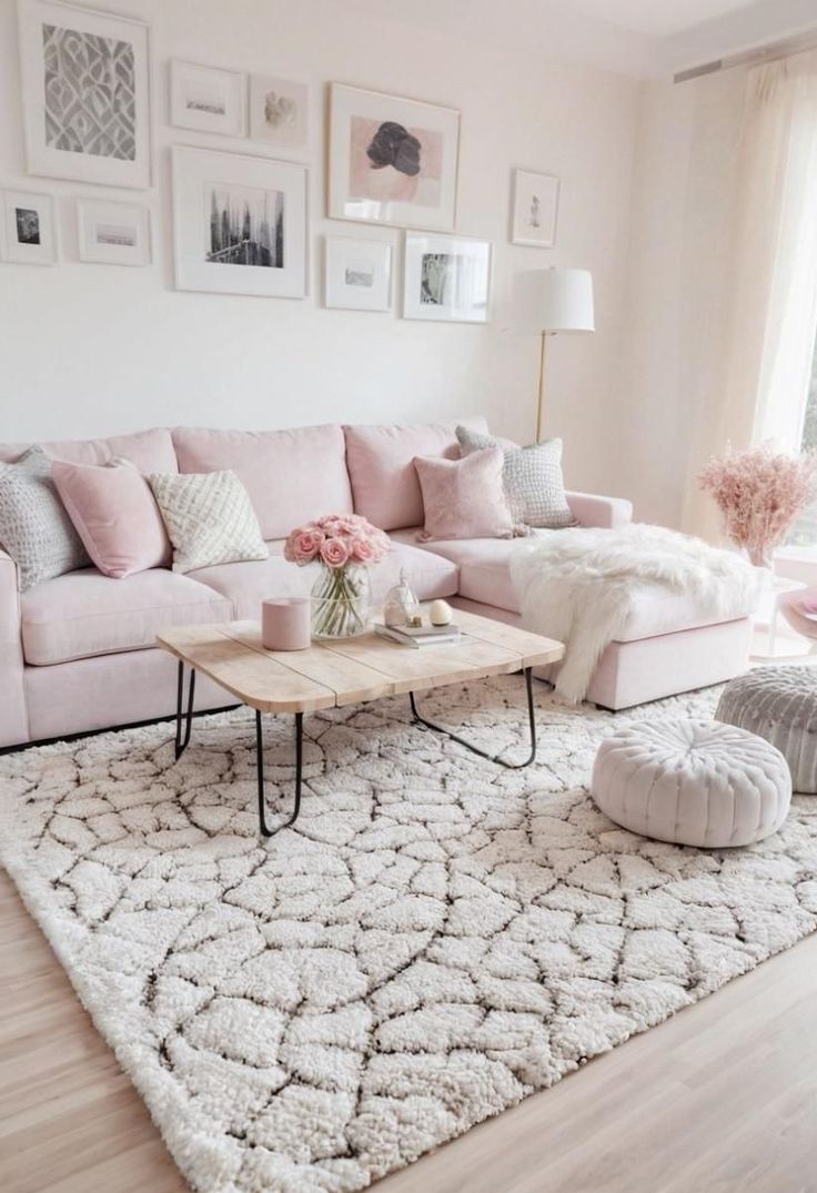 a living room with pink couches and white rugs on the floor in front of windows