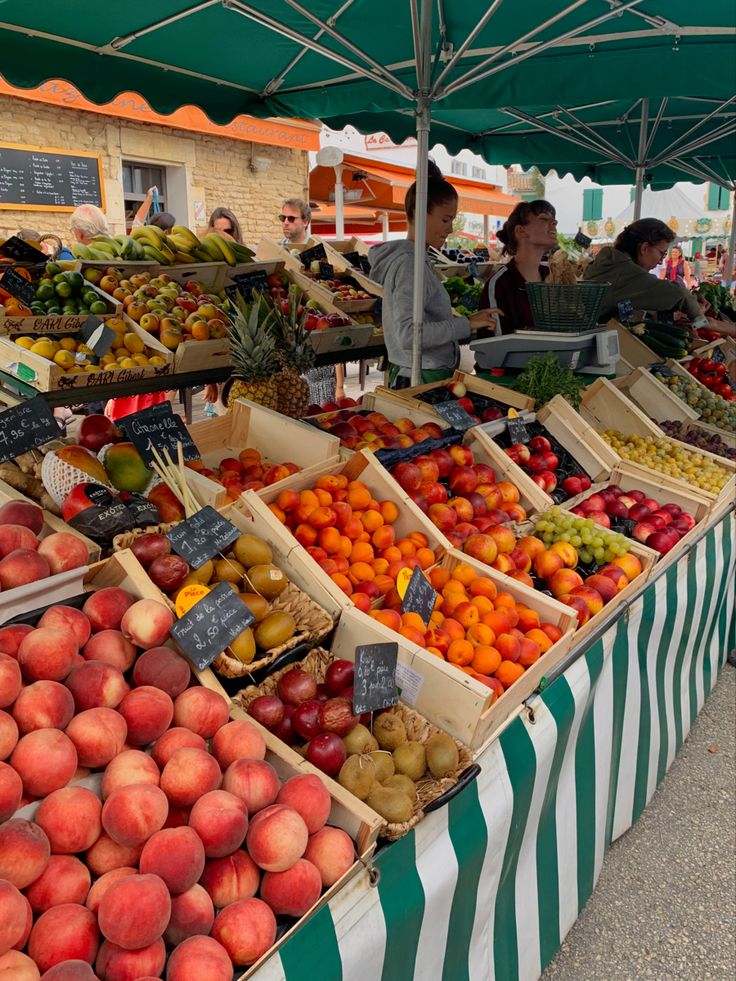 an outdoor market with fruits and vegetables on display