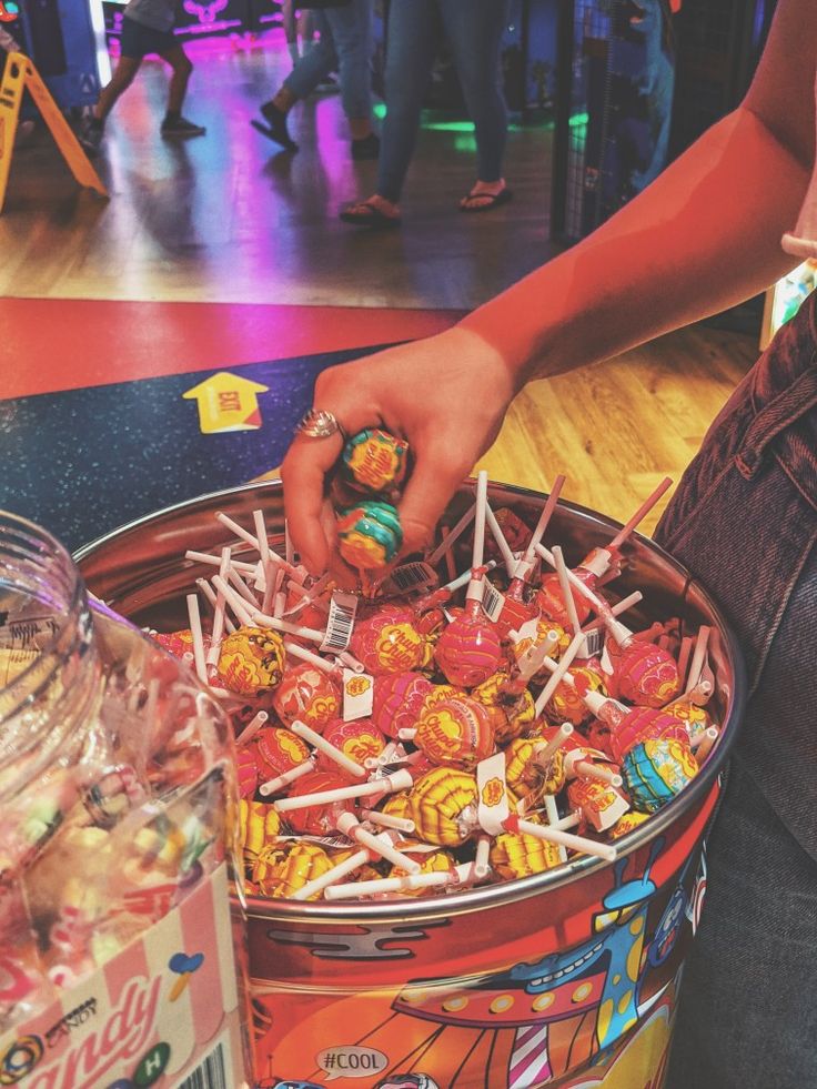 a person picking up candy from a bucket