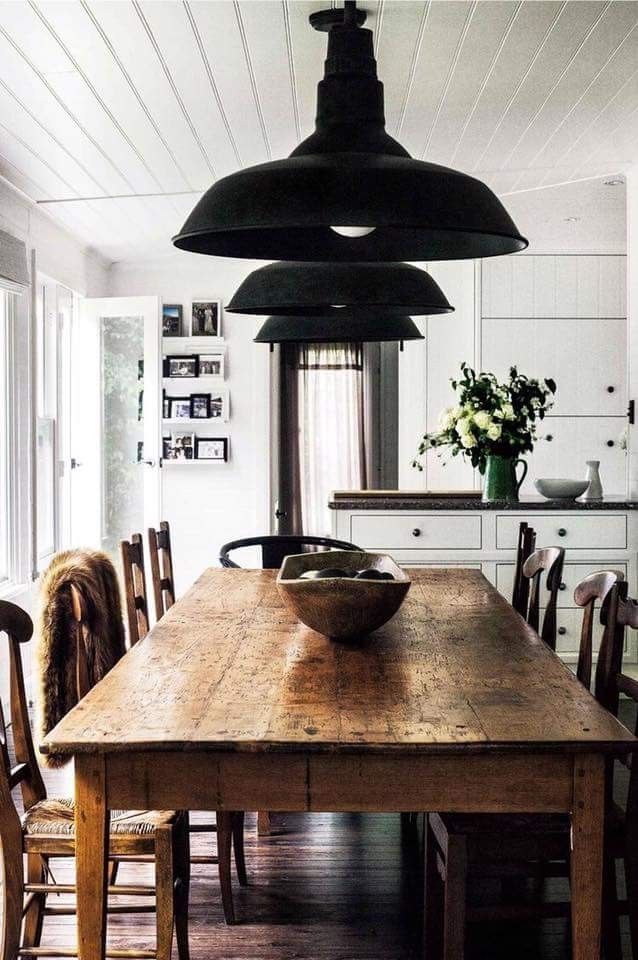 a large wooden table sitting in the middle of a room with lots of chairs around it