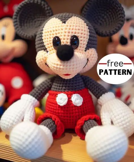 a crocheted mickey mouse sitting on top of a table next to other stuffed animals