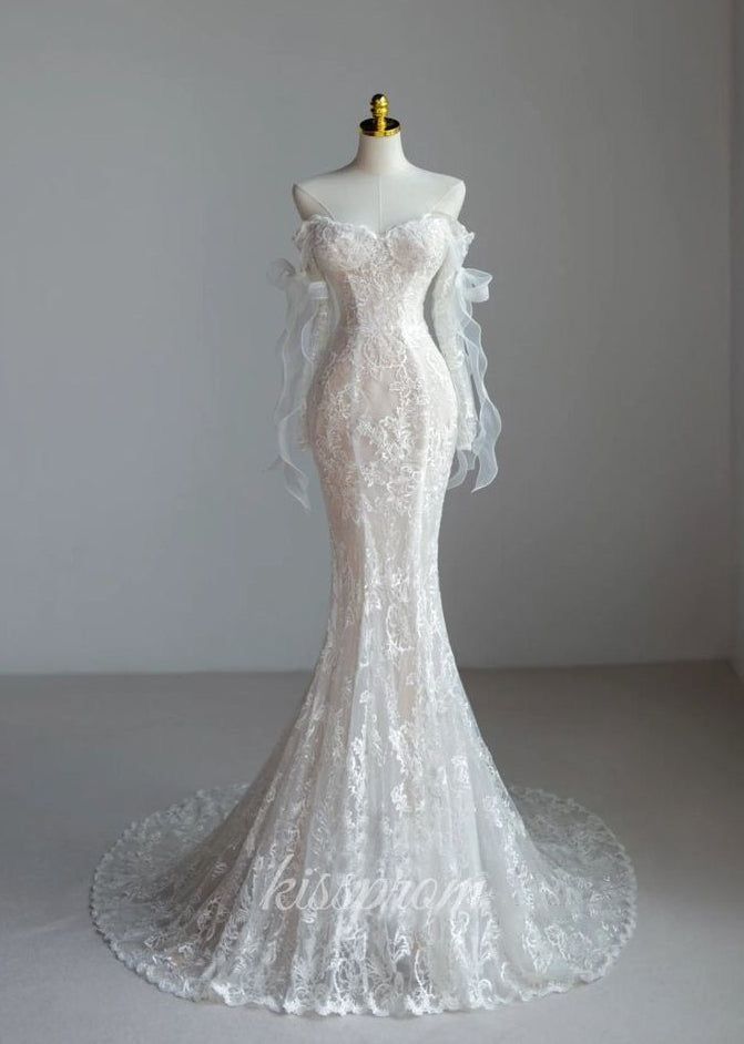 a white wedding dress with long sleeves and an off the shoulder neckline, on a mannequin