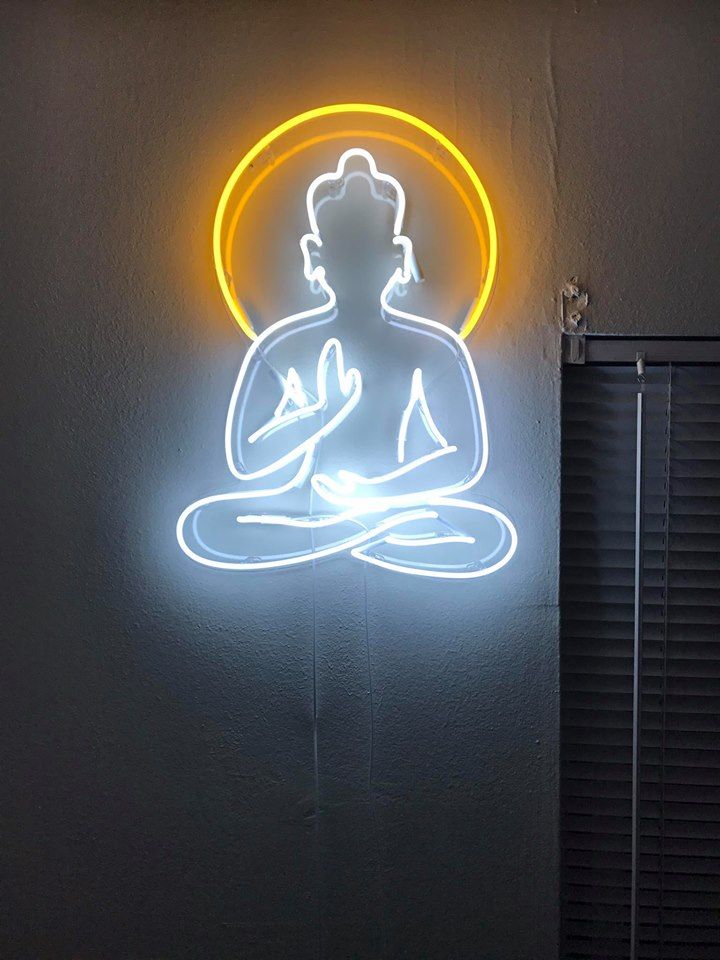 a neon sign with a buddha figure on it