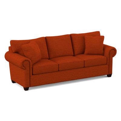 an orange couch sitting on top of a white floor