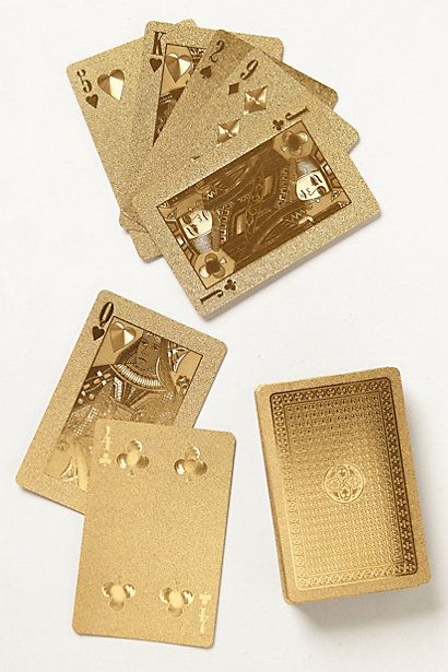 four gold playing cards on a white surface