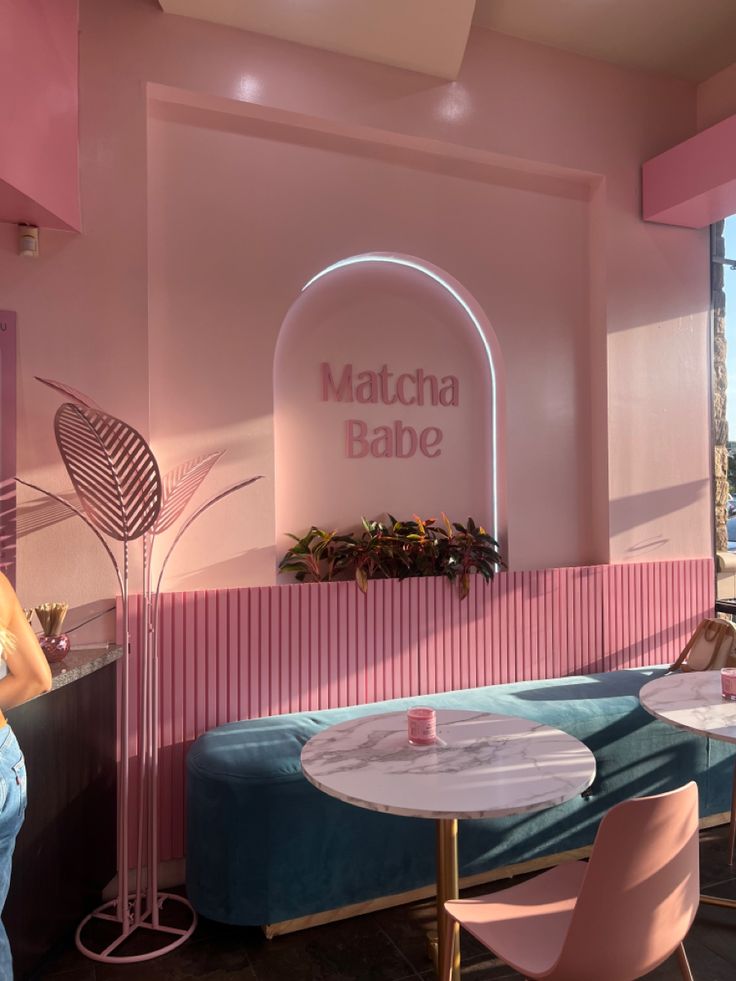 the interior of a restaurant with pink walls