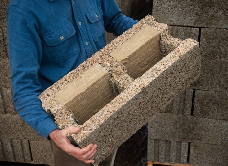 a man is holding some kind of box made out of concrete blocks and sand in his hands