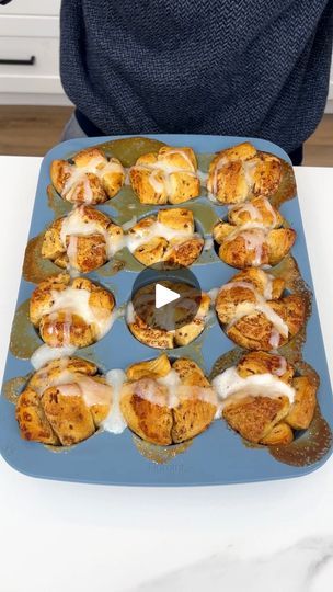 a blue tray filled with muffins on top of a white counter next to a person