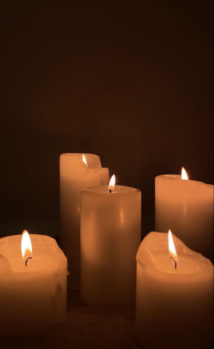 several lit candles are arranged in a row