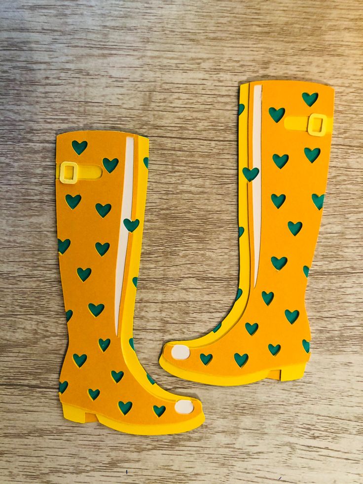 a pair of yellow rain boots sitting on top of a wooden table