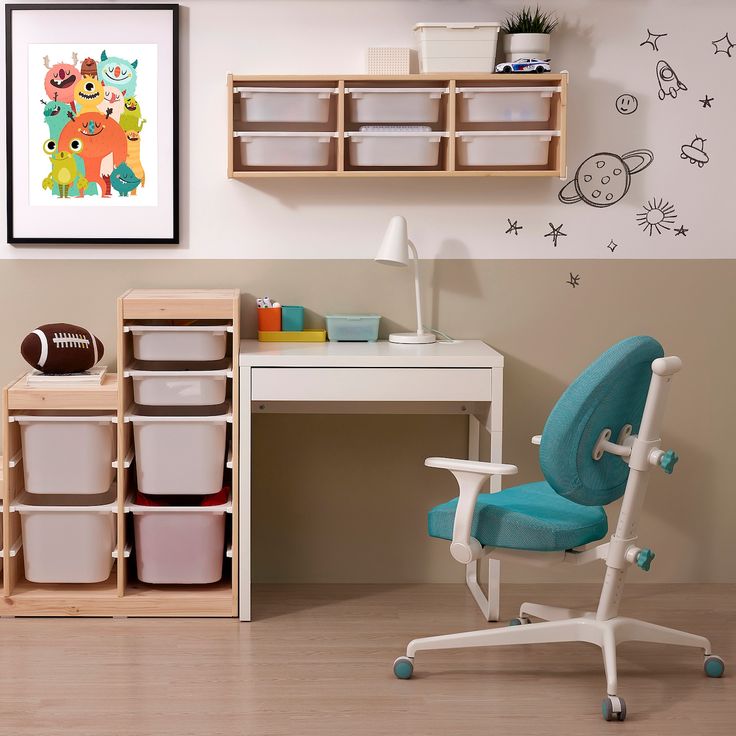 a child's desk and chair in a room with toy storage bins on the wall