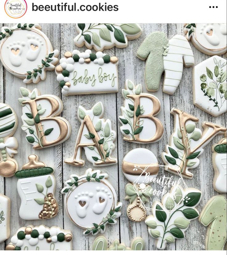 decorated cookies with green leaves and letters on them are sitting next to each other in front of a wooden table