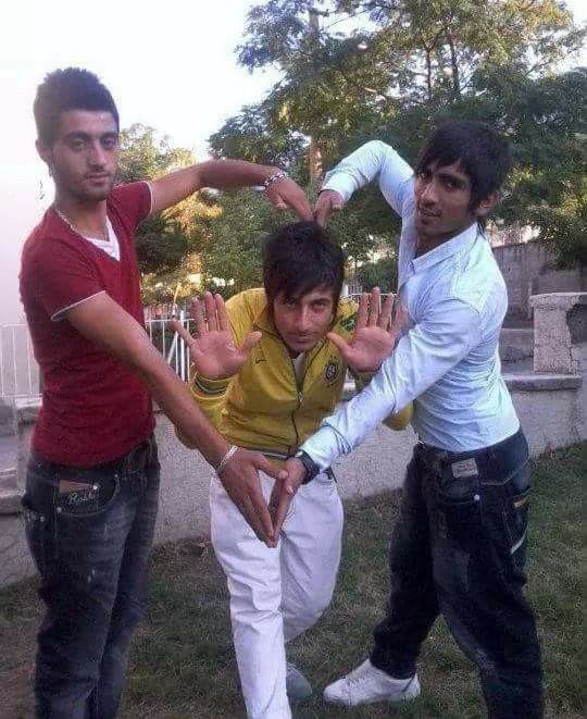 three young men posing for the camera with their hands in the shape of a heart