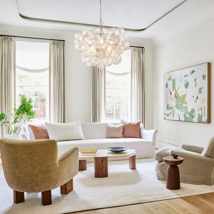 a living room filled with furniture and a chandelier hanging over the top of it