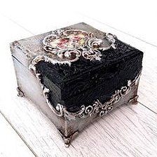 an old black box sitting on top of a white wooden floor