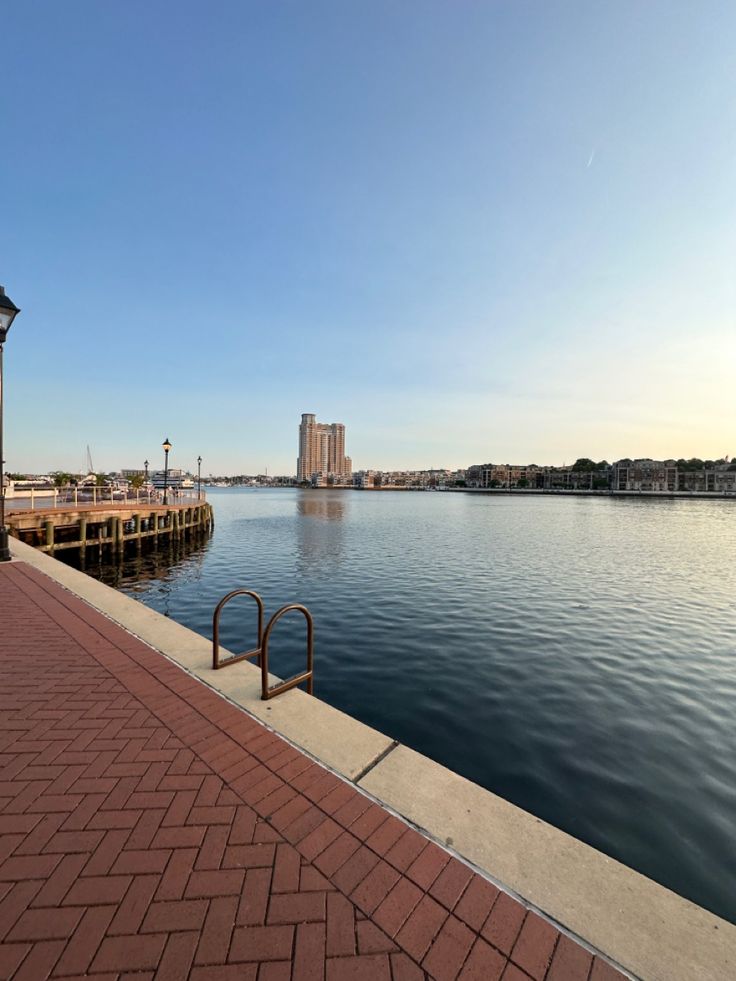 there is a view of the water and buildings in the distance from this sidewalk area