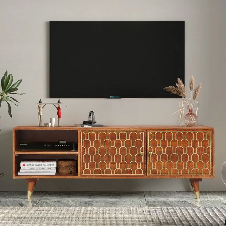 an entertainment center in a living room with a large screen on the wall above it