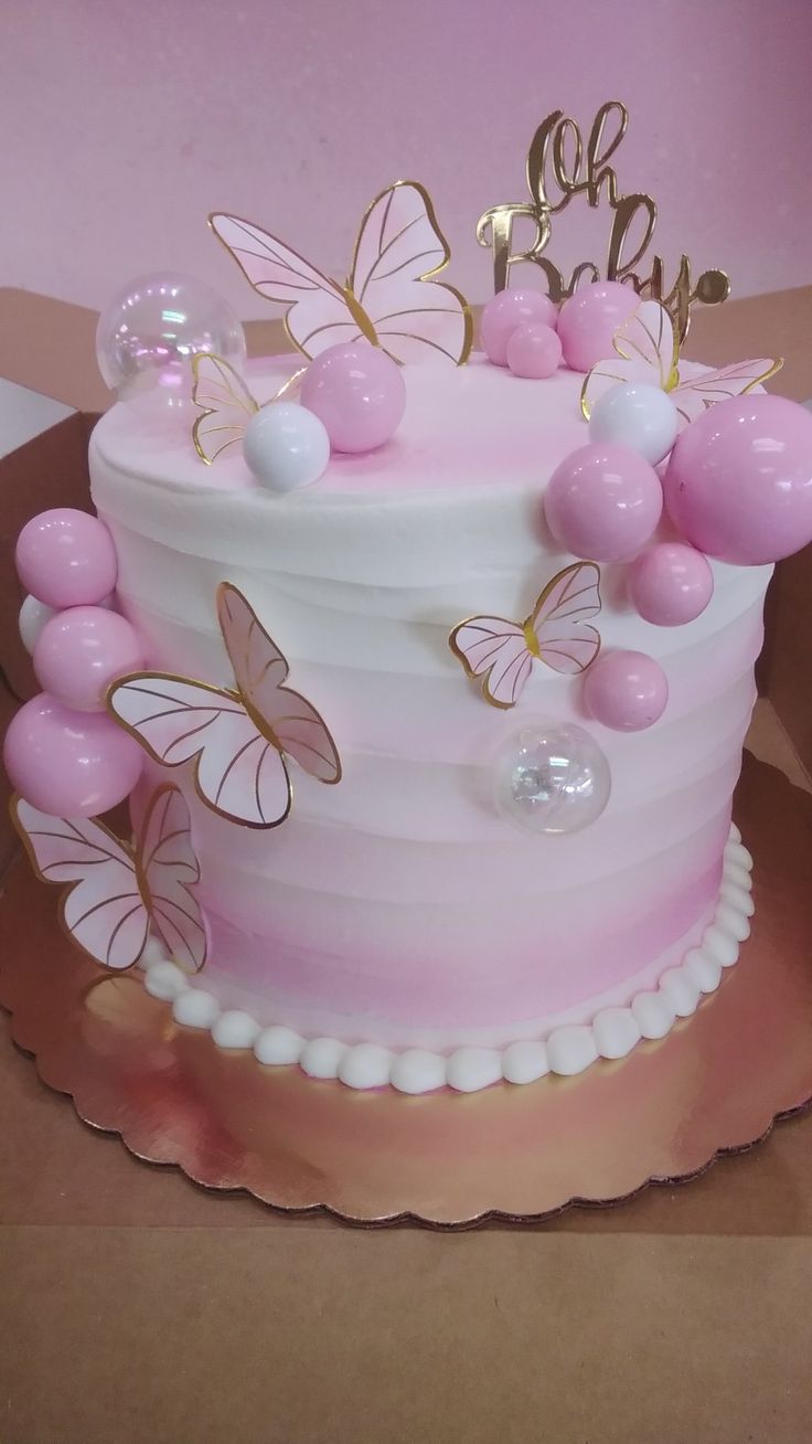 a pink and white cake with butterflies on it