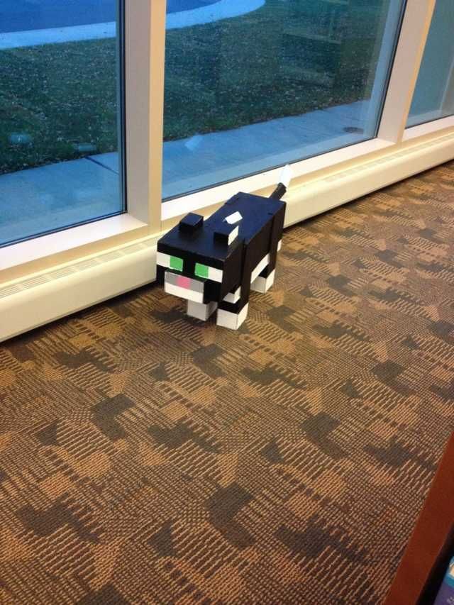 a paper toy sitting on the floor next to a window