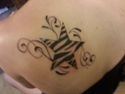 a woman's back with a zebra print tattoo on it