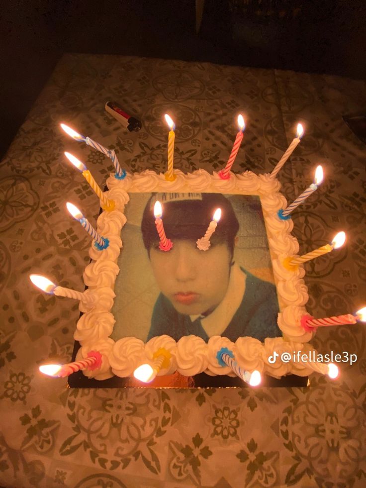 a birthday cake with candles in the shape of a photo on it and an image of a woman's face