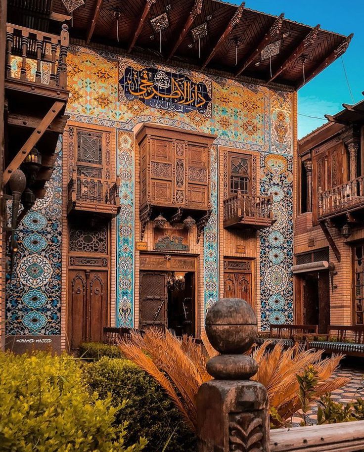 an intricately decorated building with wooden doors and balconies in the middle of it