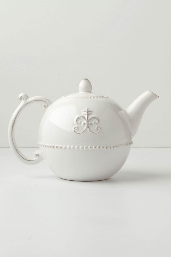 a white tea pot sitting on top of a table