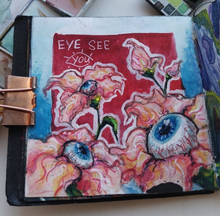 an art journal with flowers and words written on the cover, surrounded by other items