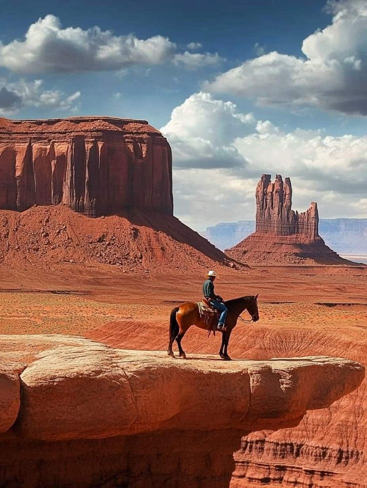 a man riding on the back of a brown horse across a desert landscape with mountains in the background