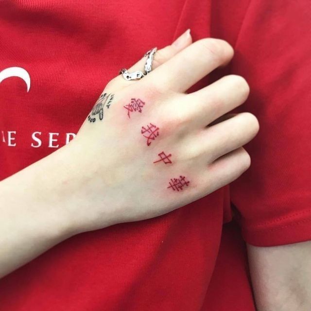 a woman's hand with tattoos on it and the word love spelled in red ink