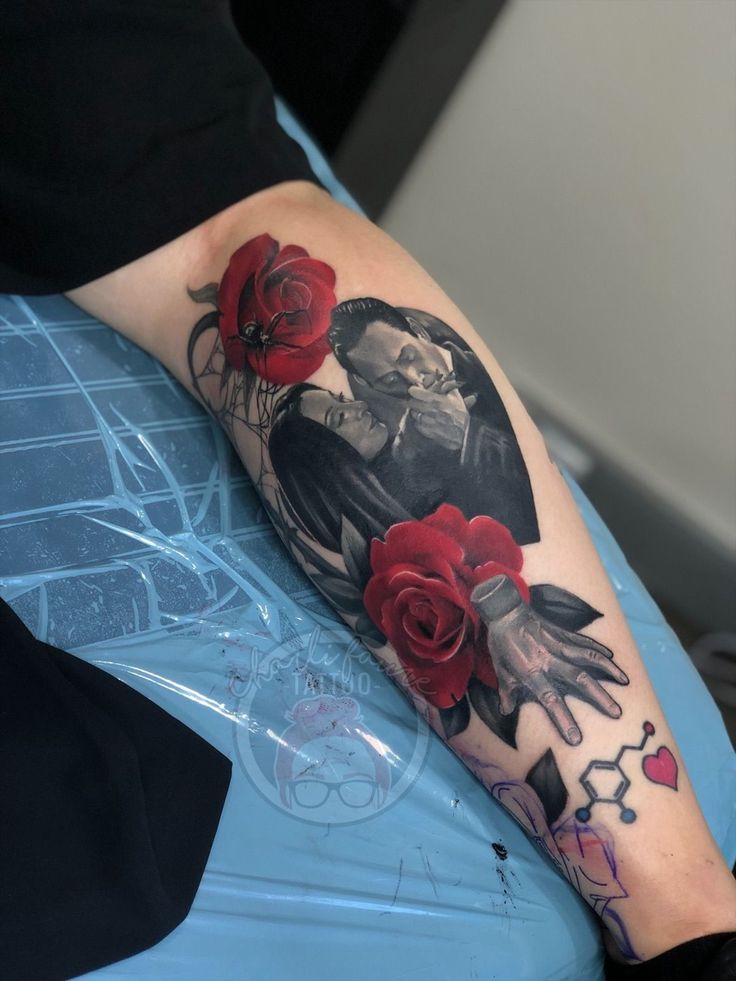 a woman's arm with red roses on it