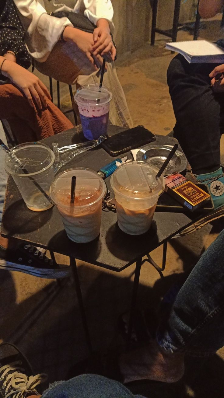 three people sitting at a table with drinks