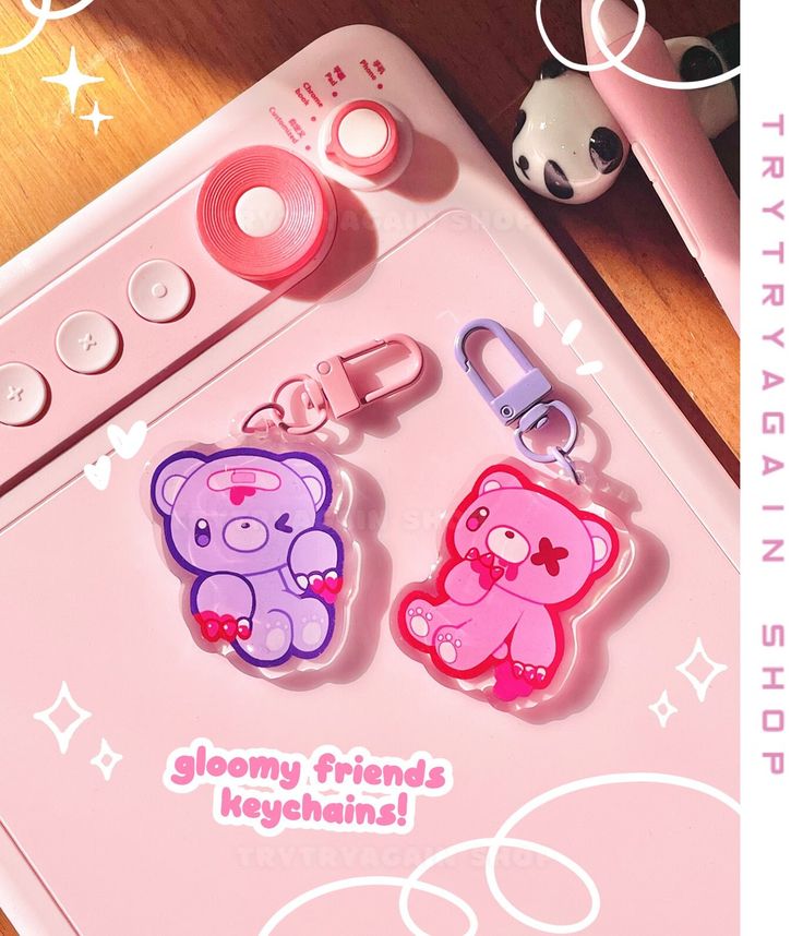 two pink and purple teddy bears are attached to key chains