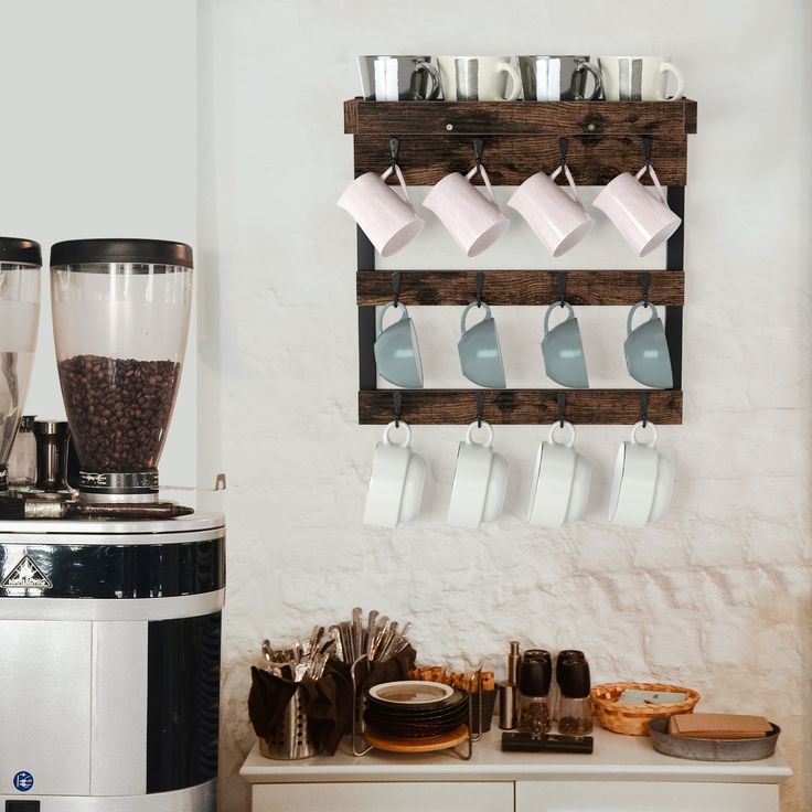 a coffee maker sitting on top of a counter next to a wall mounted cup rack