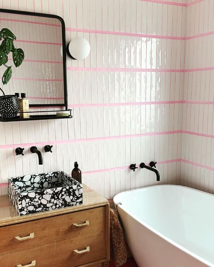 a white bath tub sitting next to a wooden dresser