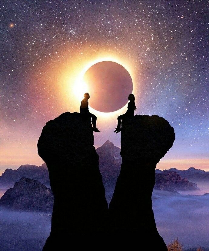 two people sitting on the edge of a cliff looking at an eclipse in the sky