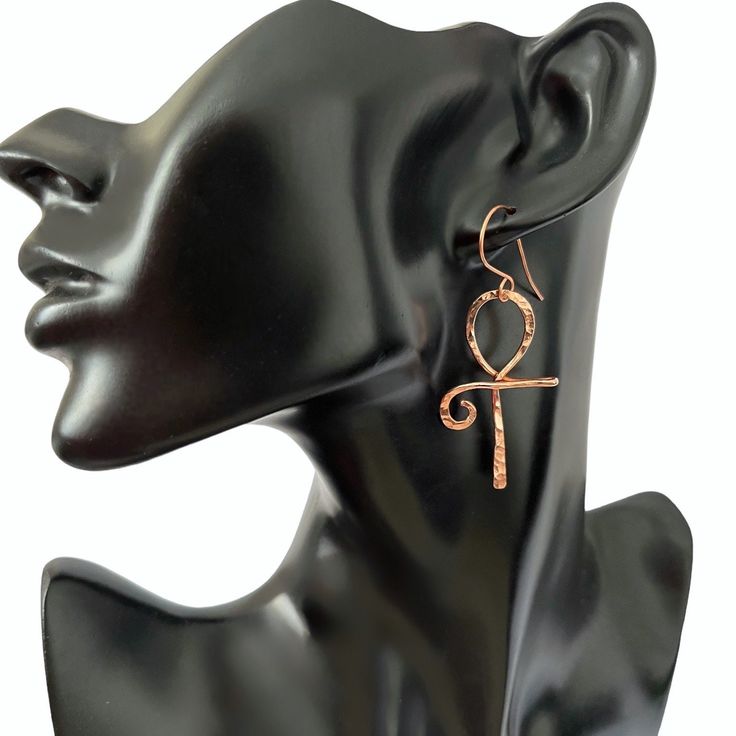 This pair of ankh earrings are lovely and symbolic. The ankh is an ancient Egyptian symbol which is also known as the key to the Nile and the key to life.  To make these earrings I formed  pure copper into the ankh shape and then lightly hammered the copper resulting in a beautiful texture which resembles diamond cuts.  To keep the copper tarnish free I coat the earrings with a tarnish resistant jewelry  protector. These earrings measures approximately 2 1/2 inches in length and 1 inch at widest point. Your earrings will arrive ready for gift giving in an organza gift bag or a cotton filled gift box  💝 Ankh-shaped Metal Earrings For Gift, Ankh Shaped Metal Earrings For Gift, Wind Jewelry, Aluminum Wire Jewelry, Egyptian Earrings, Hoop Earrings Diy, The Ankh, Ancient Egyptian Jewelry, Wire Jewelry Earrings