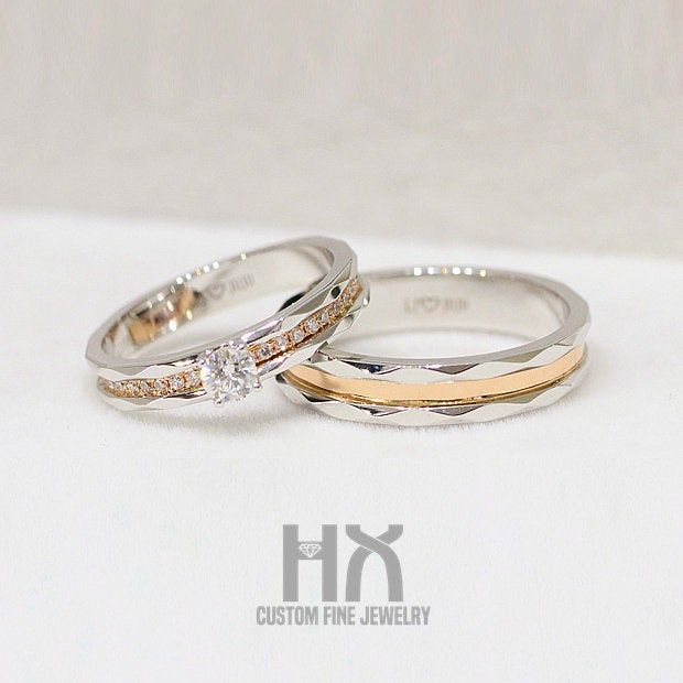 two white and yellow gold wedding rings with diamonds on them, sitting next to each other